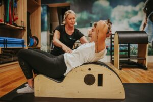 A personal trainer is giving exercise training to a lady.