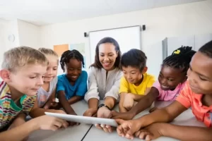 A caregiver is helping children in learning as part of NDIS services.